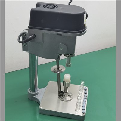 Malý elektrický stroj na uzavírání lahviček